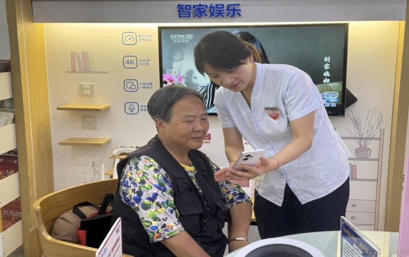 工作人员向老年用户讲解智能手机使用方法。浙江移动供图